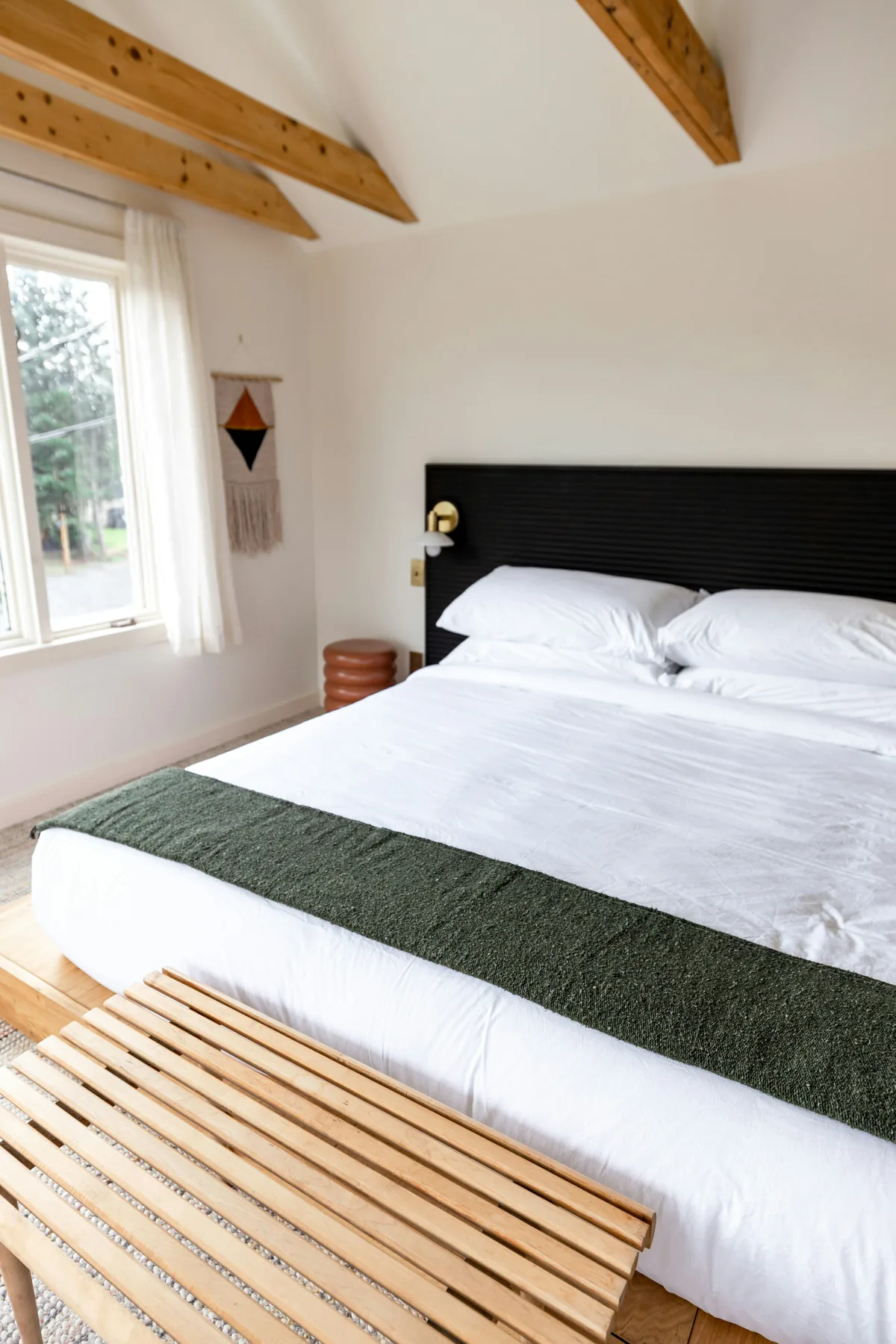 Bright guest room with white bedding and exposed timber beams