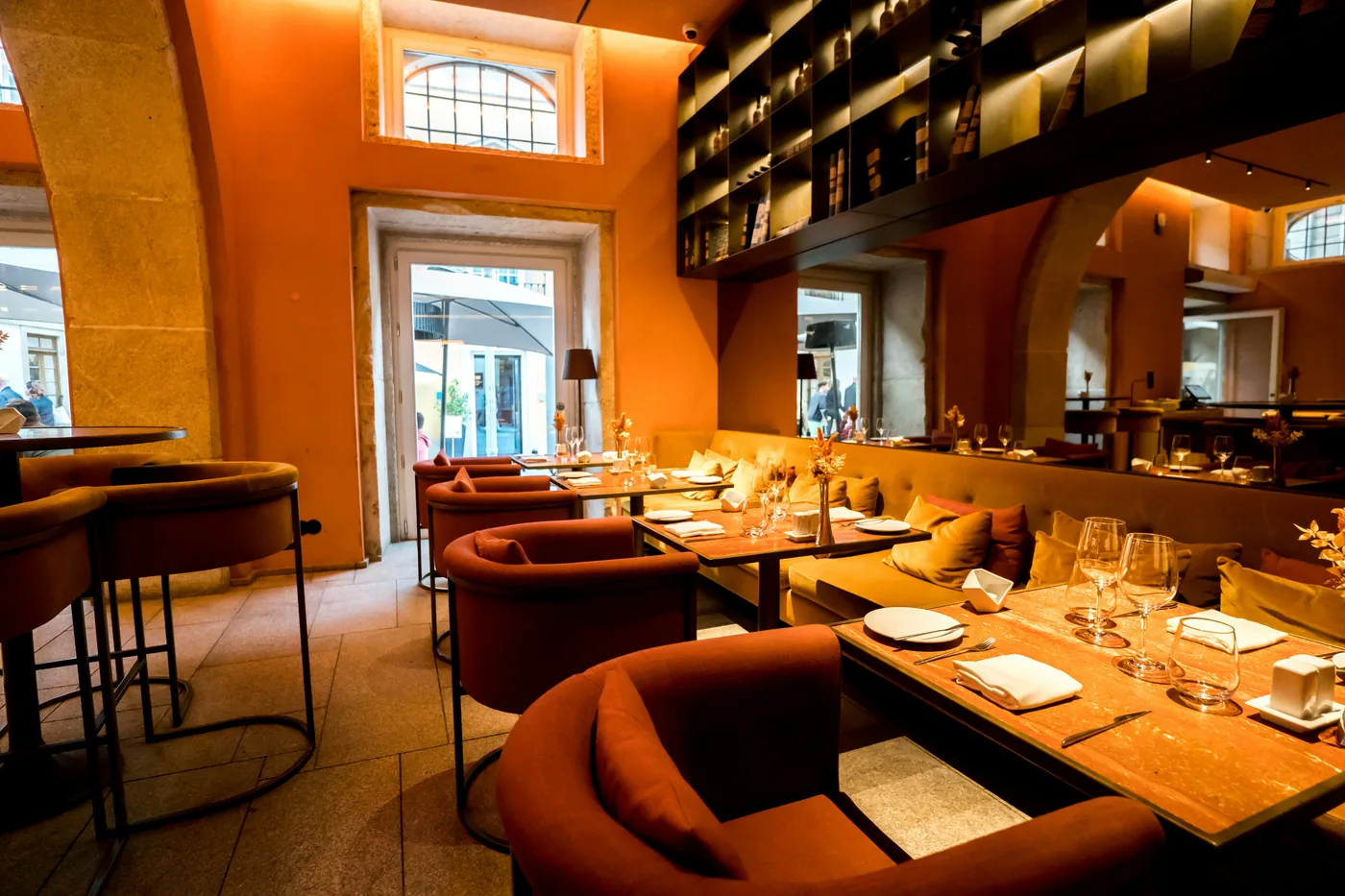 Warm restaurant interior with set dining tables and upholstered seating