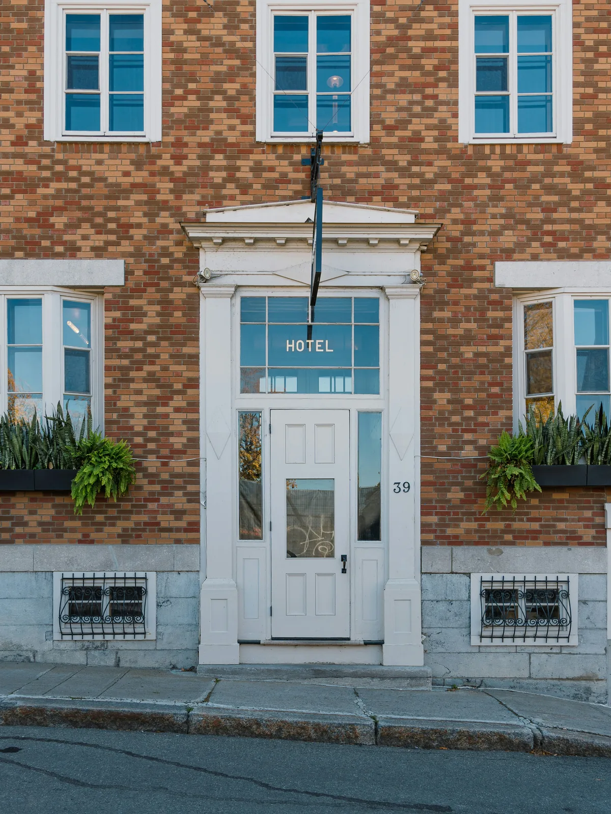Brick hotel facade with a centered white entrance